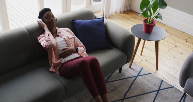 Relaxed Woman Enjoying Music on Couch in Bright Living Room - Download Free Stock Images Pikwizard.com