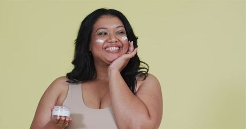 Confident Woman Enjoying Application of Skincare Cream