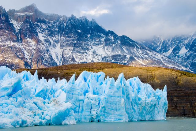 Stunning shot of Perito Moreno Glacier with jagged ice formations against the rugged mountain range in Patagonia. Ideal for use in travel blogs, adventure tourism promotions, nature documentaries, and environmental conservation materials.