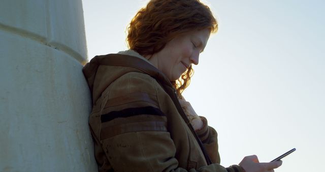 Young woman with curly hair texting on smartphone outdoors - Download Free Stock Images Pikwizard.com