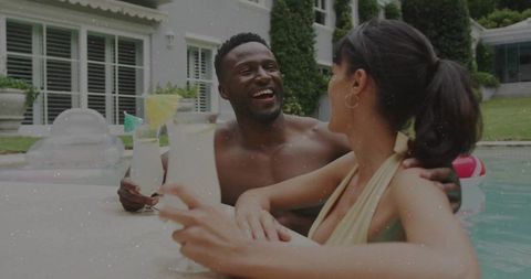 Couple relaxing by the poolside with refreshing cocktails