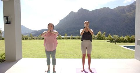 Women Practicing Yoga Outdoors in Scenic Mountain Landscape