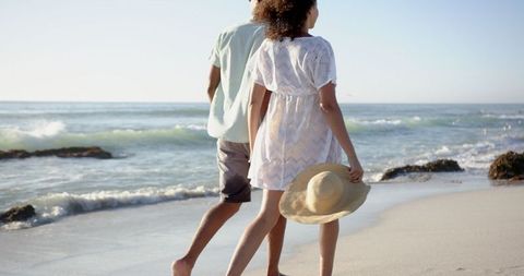 Biracial Couple Strolling along Tranquil Beach under Soft Sunlight - Download Free Stock Images Pikwizard.com