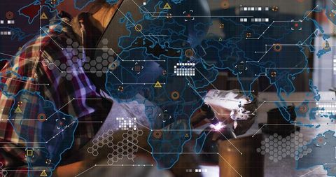 Female Welder Operating Torch and Creating Sparks with Holographic World Map Overlay
