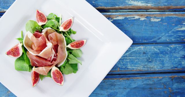 Gourmet Salad with Fig Wedges and Prosciutto on Rustic Blue Table - Download Free Stock Images Pikwizard.com