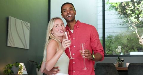 Interracial Couple Enjoying Celebration with Champagne at Home