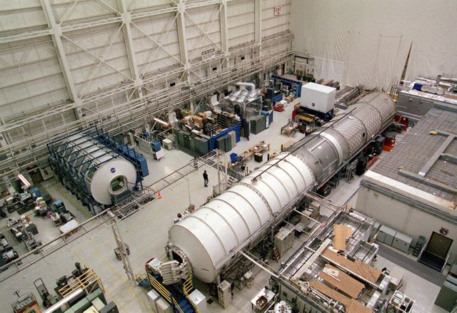 Image shows scientists and engineers at the Marshall Space Flight Center (MSFC) engaged in testing and development of Environmental Control and Life Support Systems (ECLSS) for the International Space Station (ISS). Key elements include the U.S. Laboratory Module Simulator, Node 1 Simulator, and Node 3/Habitation Module Simulator, alongside the ITCS Simulator used for controlling temperature of the equipment. Can be used to depict space research, engineering processes, teamwork, and innovations in aerospace.