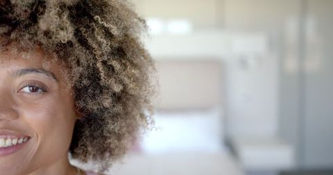 Close-Up of Woman Smiling with Curly Hair Indoors