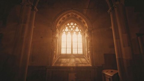 Gothic cathedral window with streaming amber light