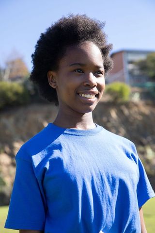 Smiling Teen Girl Enjoying Bright Outdoor Day in Blue T-Shirt