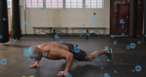 Shirtless man performing push-up in boxing gym with sale icons overlay for fitness marketing