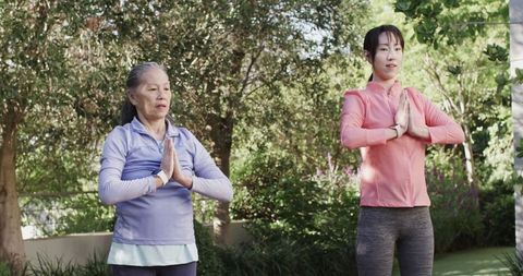 Mother and Daughter Yoga Practice in Garden with Smartwatches