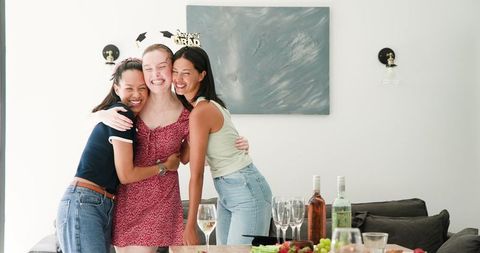 Cheerful graduates celebrating with joyful embrace