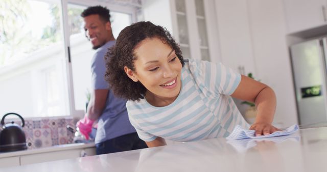 Happy african american couple washing dishes in kitchen. Spending quality time at home together concept.