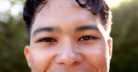 Close-up of young man with thoughtful expression in nature