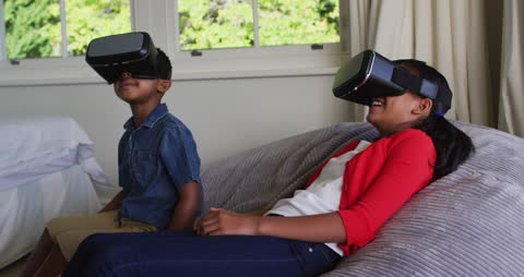 Siblings Experiencing Virtual Reality Joy on Couch