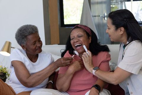African american senior women laughing during oral care and self-care at home