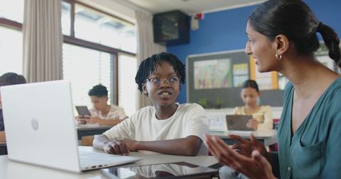 Engaging classroom dialogue between teacher and student with laptop