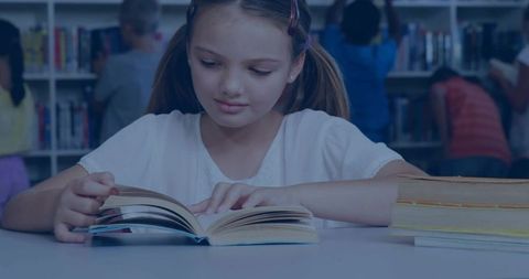 Young hispanic girl reading at school library table