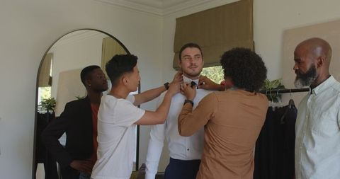 Groomsmen Assisting Groom in Preparing Wedding Attire