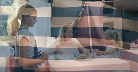 Mother and daughters enjoying pretend tea under blanket fort