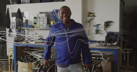 Smiling technician in workshop with wheelchair components