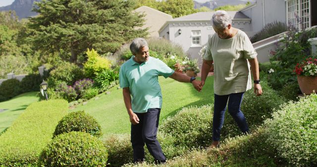 Image of happy biracial senior couple holding hands and walking in garden - Download Free Stock Photos Pikwizard.com