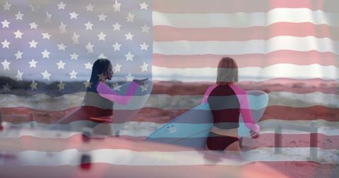 Two Women with Surfboards and USA Flag Overlay on Beach