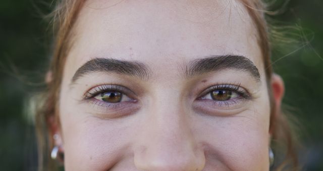 Close-up of a woman's face highlighting her natural eyebrows and bright eyes. This image can be used for beauty and skincare advertisements, personal care product promotions, fashion magazines, or facial recognition technology presentations.