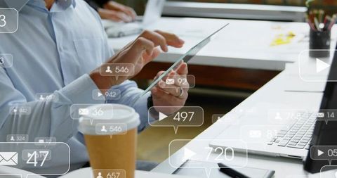 Adult man tapping transparent tablet showing social media notifications overlay at coworking desk