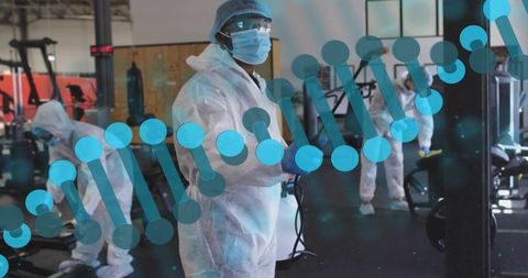 Female worker wearing full ppe disinfecting fitness center with fogger, dna helix overlay