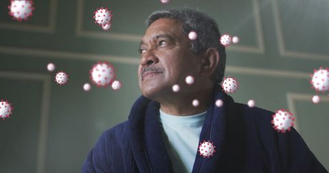 senior man wearing dark robe looking contemplatively while digital viruses surround him, symbolizing covid-19. reflects themes of concern, pandemic impact, mental health awareness. useful for articles discussing pandemic effects on seniors or health, and public awareness campaigns on virus prevention.