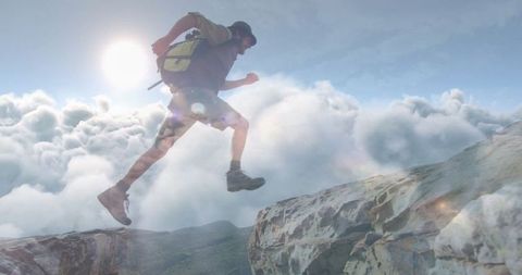 Adventurer Crossing Mountain Ledges Above Cloudscape