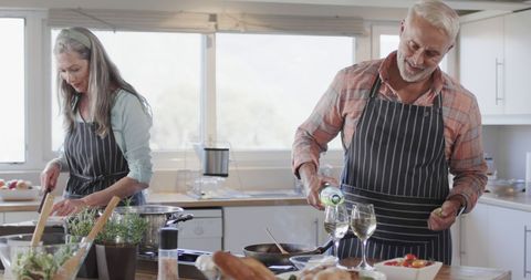 Middle-Aged Couple Enjoying Cooking and Wine at Home - Download Free Stock Images Pikwizard.com