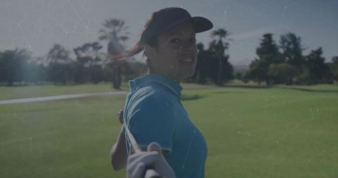 Confident female golfer with club on fairway in sunlit setting