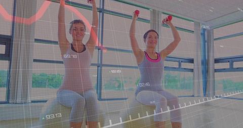 Two Women Lifting Red Dumbbells While Seated on Benches with Digital Fitness Metrics