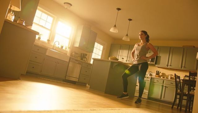 Morning stretching routine in sunlit kitchen promoting home fitness and wellness lifestyle
