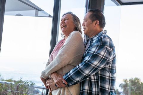 Diverse Couple Embracing on Oceanfront Balcony