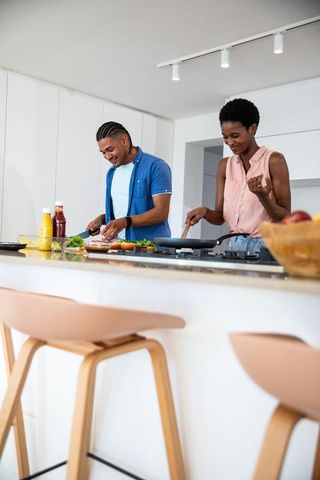 Happy couple cooking together in modern kitchen setting