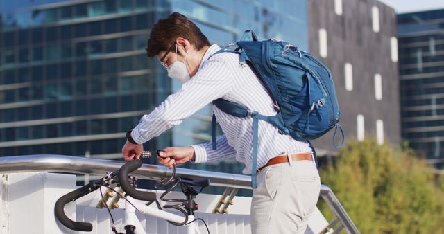 Office worker in business casual attire locking bicycle with a helmet and backpack in an urban setting. Ideal for illustrating concepts of healthy urban commuting, eco-friendly transportation, and pandemic safety measures. Suitable for use in articles, advertising, websites, or promotional materials related to city life, office culture, and active commuting.