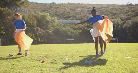 Girls Collecting Litter in a Soccer Field during Community Clean-up Drive