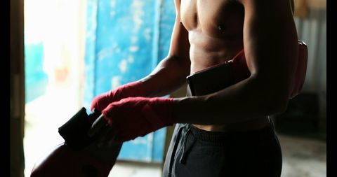 Determined Boxer Preparing in Sunlit Studio