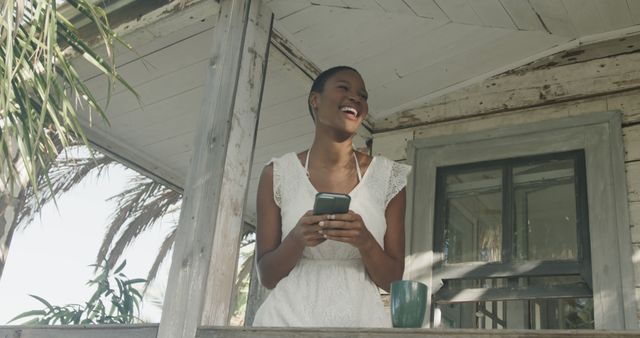 Smiling Woman on Porch Holding Smartphone Enjoying Outdoor Moment - Download Free Stock Images Pikwizard.com