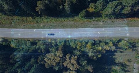Self-driving car traveling rural forest road with telemetry overlay, aerial view
