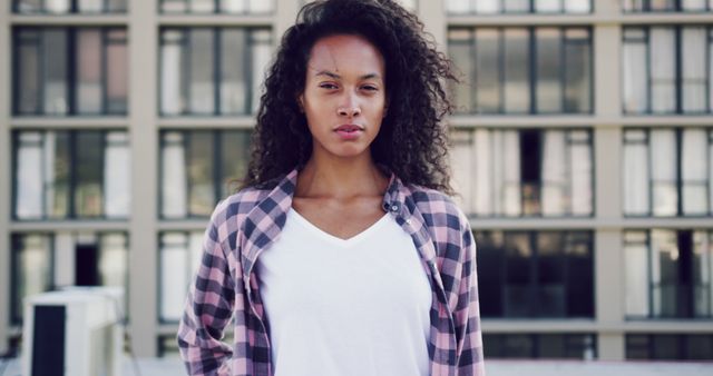 Confident Young Woman with Curly Hair in Urban Setting - Download Free Stock Images Pikwizard.com