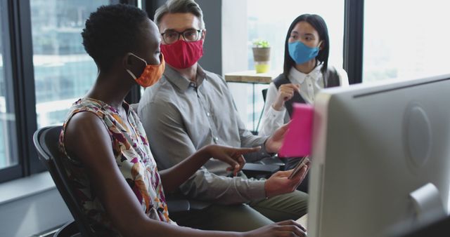 Diverse colleagues wearing face masks collaborating in modern office - Download Free Stock Images Pikwizard.com