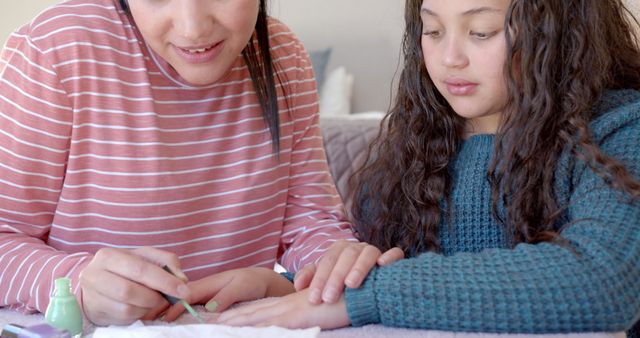 Mother applying nail polish to daughter's nails at home - Download Free Stock Images Pikwizard.com