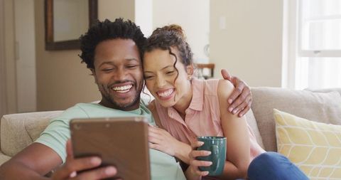 Happy Couple Using Tablet on Sofa During Video Call