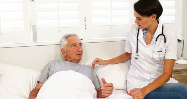 Nurse taking care of mature man lying on a bed at hospital