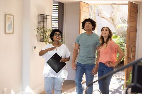 Real estate agent guiding african american women homebuyers through bright entryway